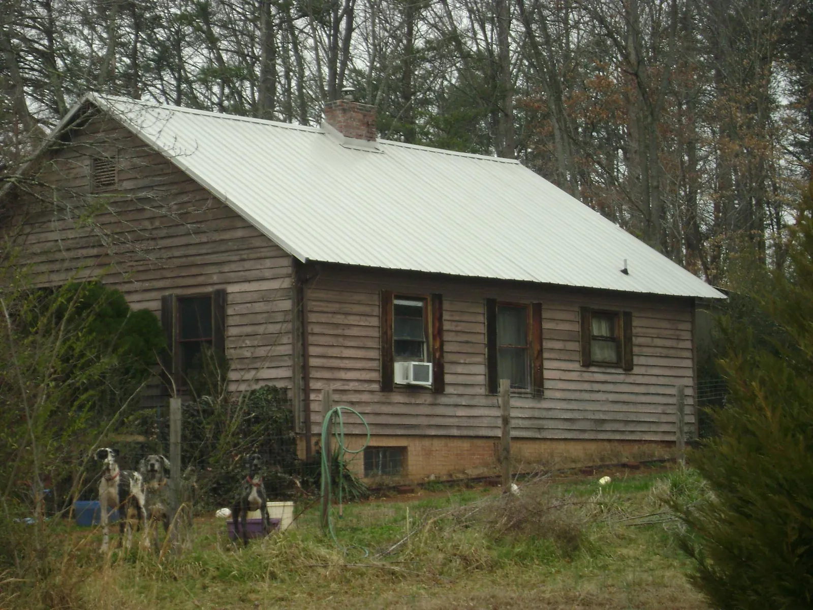 White metal roof on an old wood sided farmhouse, from a Metal Roof Installation job in Norman